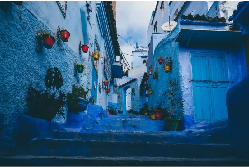 Callejón azul en Chefchaouen con arquitectura tradicional marroquí y detalles coloridos.