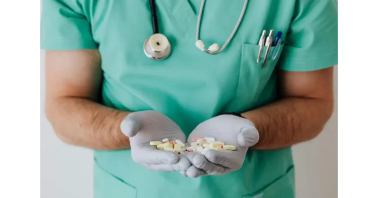 hombre mostranso en su mano unas pastillas medicas